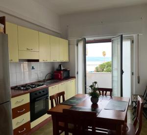 a kitchen with a table and a view of the ocean at Stella Marina Home Holidays in Gioia Tauro