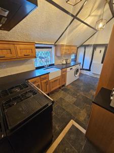 una cucina con mobili in legno e un forno a piano cottura di Beautiful historic cottage pets welcome a Birchington