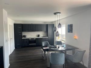 a living room with a table and chairs and a kitchen at Luxuriöse Ferienwohnung EG in Meisenheim