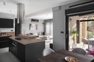 eine Küche und ein Wohnzimmer mit Tisch und Stühlen in der Unterkunft Villa Anthea and Paola in Nedeščina