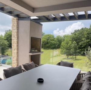 einen weißen Tisch mit Stühlen und ein großes Fenster in der Unterkunft Villa Anthea and Paola in Nedeščina