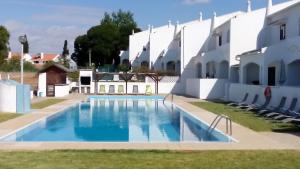 a swimming pool in front of a building at Vila Olímpica in Albufeira