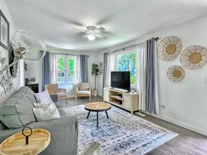 a living room with a couch and a tv at Blue Bungalow huge yard & king bed in Charleston