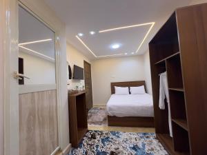 a small bedroom with a bed and a mirror at Isis Pyramids View Inn in Cairo