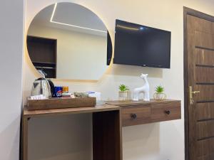 a room with a desk with a tv and a mirror at Isis Pyramids View Inn in Cairo