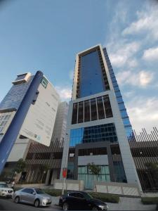 Un edificio alto con coches aparcados delante. en Studio in Business bay, Metro!, en Dubái