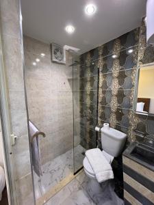 a bathroom with a toilet and a glass shower at Isis Pyramids View Inn in Cairo