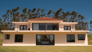 a house with a balcony on top of it at Sitio Lipa - Villa da Mata in São Miguel Arcanjo