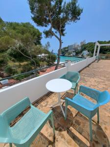 a table and chairs on a balcony with a view of the water at Hostal Playa in Cala Santanyi