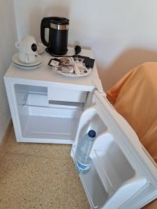 a small white table with a water bottle on it at Hostal Playa in Cala Santanyi