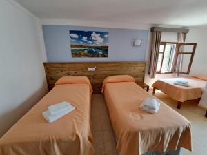 a bedroom with two beds in a room at Hostal Playa in Cala Santanyi +37 photos