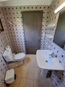 a bathroom with a sink and a toilet and a mirror at Hostal Playa in Cala Santanyi