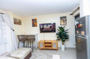 a living room with a refrigerator and a table at Polea Hapa tu in Ngong