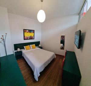 a bedroom with a large white bed with yellow pillows at Flying Dog Hostel in Lima
