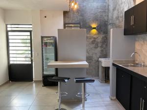 a kitchen with two stools and a refrigerator at Estudios Rios Habitación in Zamora de Hidalgo