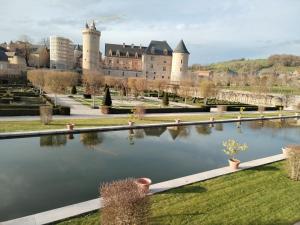 a view of a castle with a lake in front of it at Chambre Auberge du donjon in Bournazel