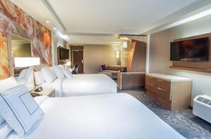 a hotel room with two beds and a flat screen tv at Courtyard by Marriott Lenox Berkshires in Lenox