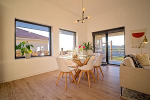 a dining room and living room with a table and chairs at Sunset Hills Transylvania in Odorheiu Secuiesc
