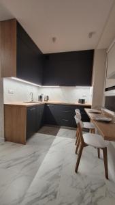 a kitchen with a sink and a table and a chair at Nowa Huta 12 in Krakow