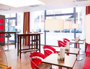 a restaurant with red chairs and tables and windows at Best Western Plus Amedia Wien in Vienna