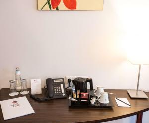 a desk with a phone and a coffee maker on it at Best Western Plus Amedia Wien in Vienna