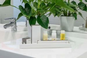 a bathroom sink with three bottles of essential oils on it at Best Western Plus Amedia Wien in Vienna