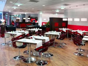 a restaurant with white tables and red chairs at Best Western Plus Amedia Wien in Vienna