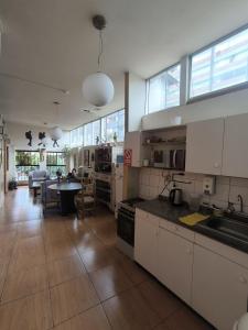 una grande cucina con armadi bianchi e una sala da pranzo di Flying Dog Hostel a Lima