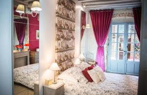 a bedroom with a bed and a wall with purple curtains at Le Nid De La Loire in Blois