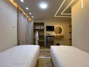 a bedroom with two beds and a tv in it at Isis Pyramids View Inn in Cairo