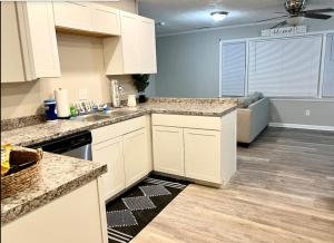 a kitchen with white cabinets and a counter top at Queen Suite - Hot Tub - Home Theater - WiFi in Jonesboro