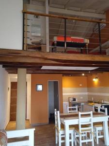 a room with a table and chairs and a kitchen at Departamento Anthony Refugio del mar in Santa Teresita
