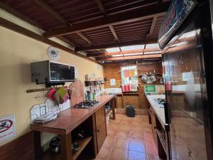 a large kitchen with a counter and a refrigerator at Hostal Hansi in Bocas Town