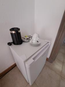a white table with a coffee pot and plates on it at Hostal Playa in Cala Santanyi