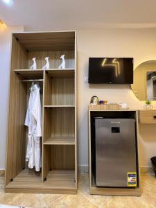 a kitchen with a refrigerator and a tv in a room at Isis Pyramids View Inn in Cairo