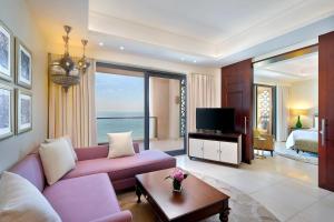 a living room with a purple couch and a tv at Ajman Saray, a Luxury Collection Resort, Ajman in Ajman 