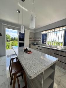 a kitchen with a counter with chairs and a table at Casa Campestre Bello Atardecer Cerca al Parque del Café con Piscina in La Esmeralda
