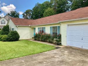 a yellow house with a white garage at Rose's House in Lanett
