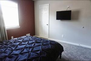 a bedroom with a bed and a television on the wall at Vintage Queen Suite - 7 mins From ATL Airport in Riverdale +20 photos