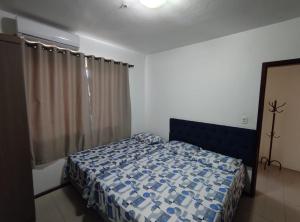 Un dormitorio con una cama con un edredón azul. en Vanessa pousada familiar, en São Gabriel