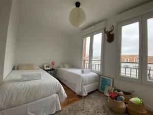 a bedroom with two beds and two windows at New Apartment Disneyland Paris Panoramic view 8 PAX, 2 parking in Serris