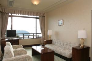 a living room with a couch and chairs and a television at Gamagori Classic Hotel in Gamagōri