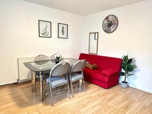 a living room with a table and a red couch at 3 Twin Bedroom Entire House Sleeps 10 Driveway Parking near Coventry University and City Center in Coventry