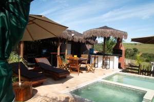a resort with a swimming pool and a table and chairs at Recanto Dos Pássaros in Araçoiaba da Serra