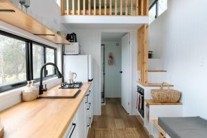 a kitchen with a sink and a refrigerator at Brand New Tranquil Tiny Home On 60 Acres Near Kennilworth Feed Friendly Cows, Spectacular Views in Obi Obi