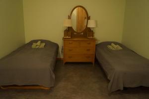 two beds in a room with a mirror and a dresser at Laplanders rooms in Kiruna