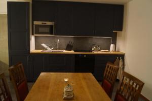 a kitchen with black cabinets and a wooden table at Laplanders room 13 in Kiruna