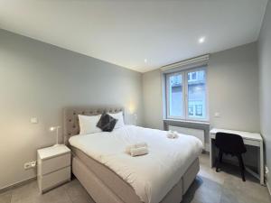 a bedroom with a bed with a desk and a window at Spacious 3 bedrooms w parking in Limpertsberg in Luxembourg