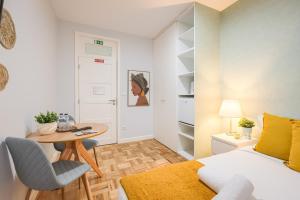 a bedroom with a bed and a table and a desk at Magnolia Inn in Aveiro