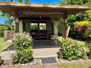 un patio con una mesa y un banco bajo un pabellón en Fare Miti Ora Moorea - Bungalow mitoyen, en Hauru